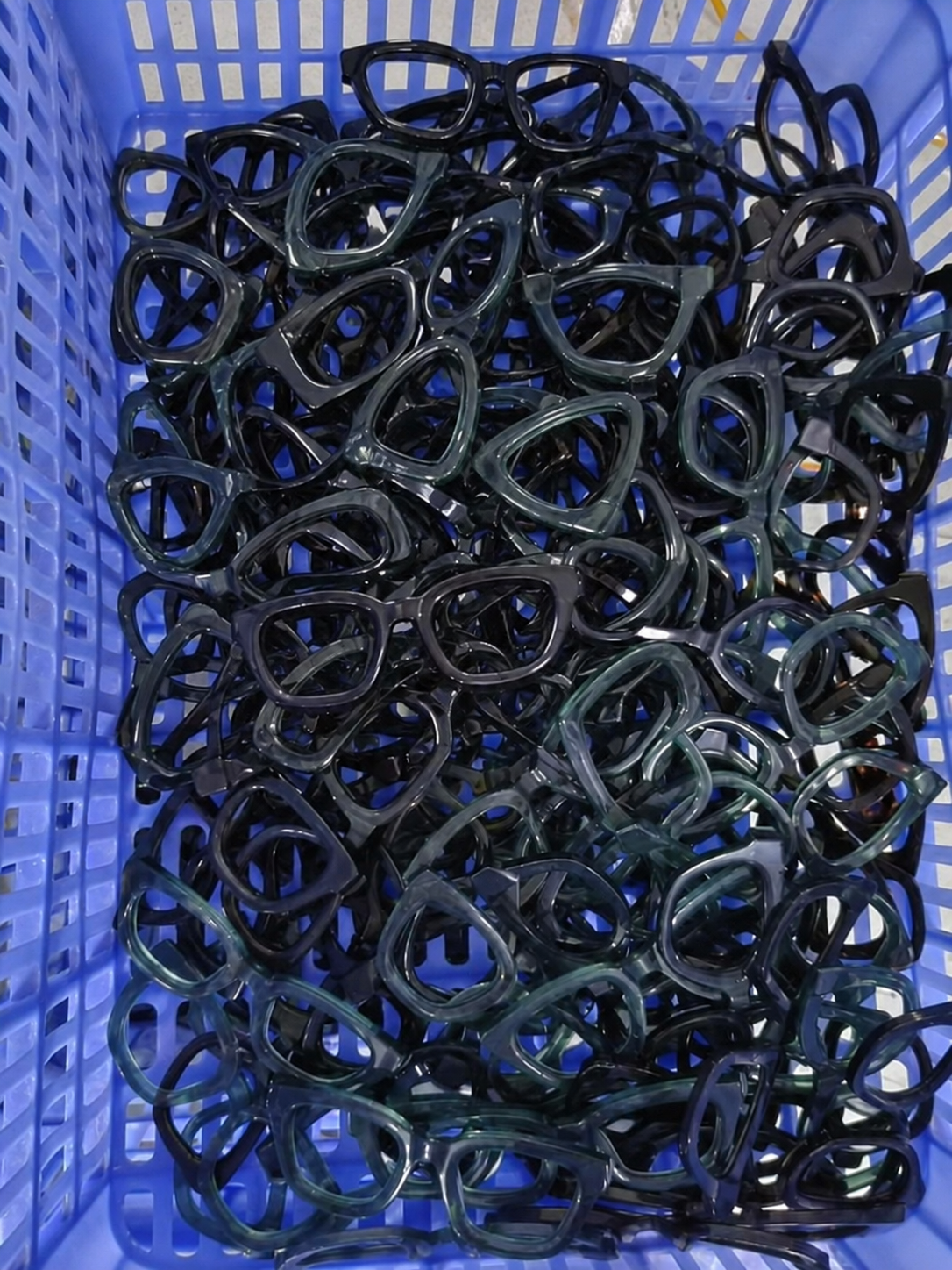 Montature in acetato mescolate in un contenitore blu