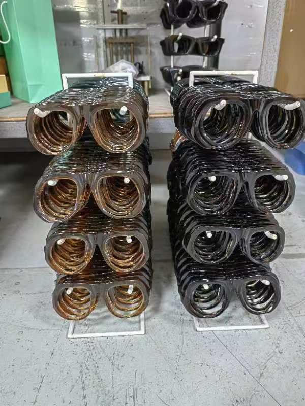 Montature in acetato impilate su supporti separati per colore